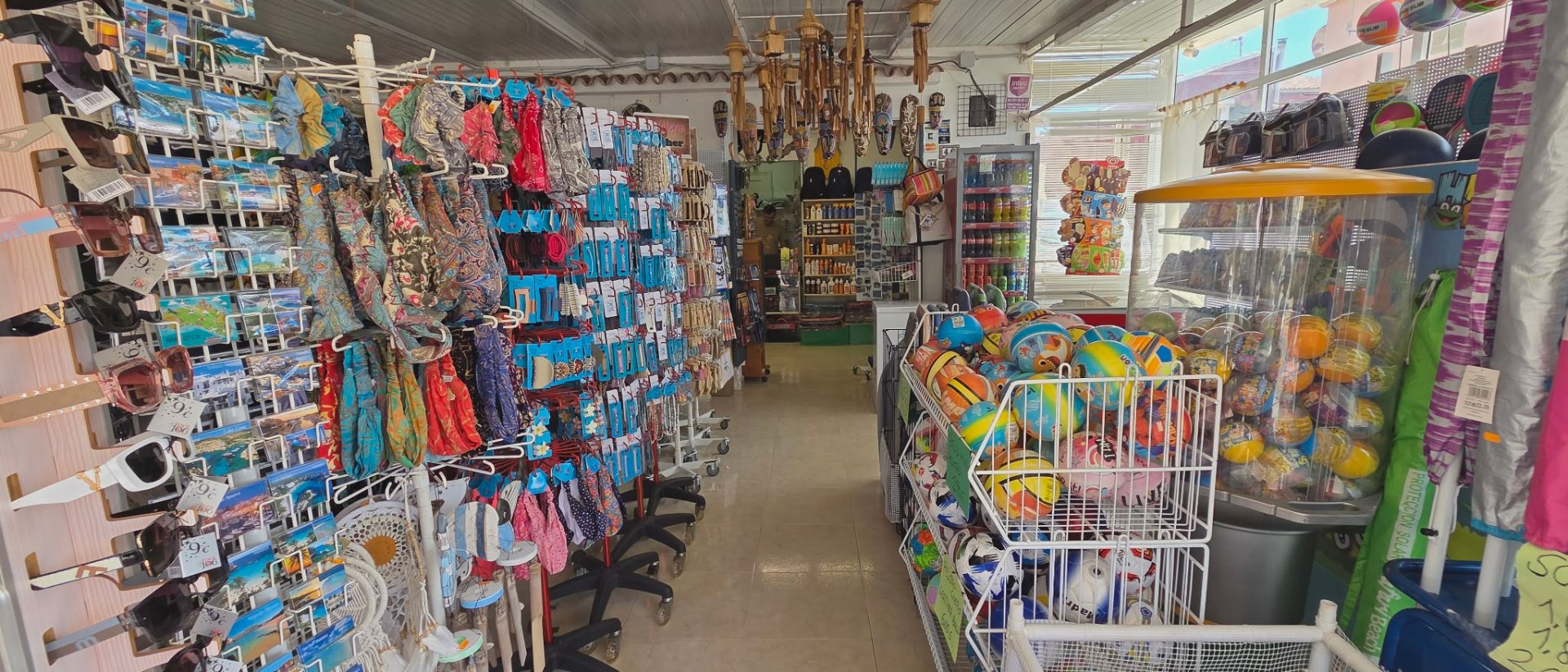 Interior de la tienda con bolsos y balones de playa